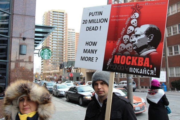 People hold placards and Ukrainian flags during a peace march from Toronto's City Hall to the Russian Consulate, in support of Ukraine on March 8, 2014, in Toronto, Ont.