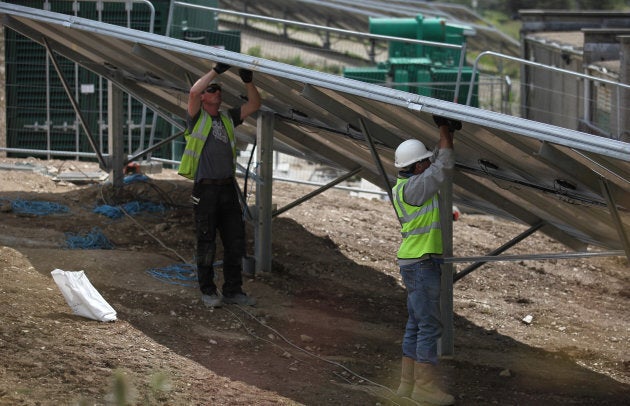 Construction workers build a solar farm.