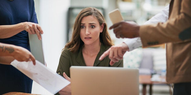 Shot of a young businesswoman looking anxious in a demanding office environment