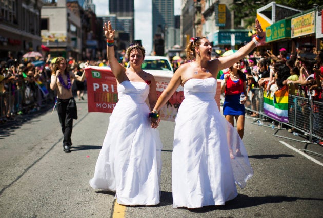 A newly wed lesbian couple marching in wedding dresses at the Toronto gay pride parade in Toronto, June 30, 2013.