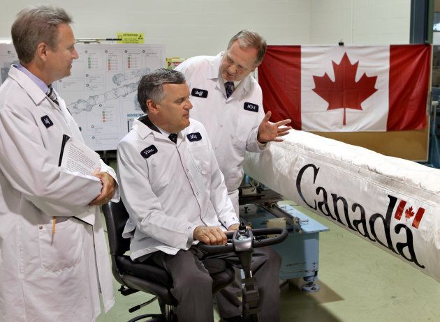 Sam Higson, Shuttle programs director for Brampton's MDA Space Missions, right, gives Ontario Lieutentant-Governor David Onley, seated, a quick rundown on the Canadarm robotic manipulator as deputy general manager Craig Thornton looks on, on July 20, 2011.