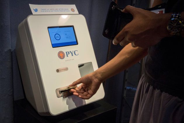 A customer feeds cash currency into a Bitcoin ATM located in Flat 128, a boutique in New York's West Village, on Aug. 22, 2014.