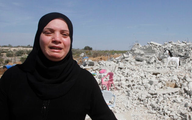 Palestinian woman Taghreed Sholi cries near the rubble of her house, which was demolished by the Israeli army, near Israel's controversial barrier in the village of Jarushiyya near the West Bank city of Tulkarm, March 9, 2015.