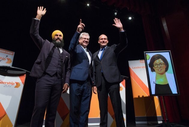 Left to right: Jagmeet Singh, Charlie Angus and Guy Caron pose for a photo, as Niki Ashton is seen on a television screen via satellite from Ottawa, before a federal NDP leadership debate in Vancouver on Sept. 10, 2017.