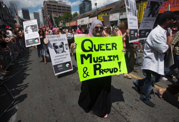 A woman carrying a sign that reads, "Queer, Muslim and Proud" marches during the Gay Pride parade in Toronto July 1, 2012.