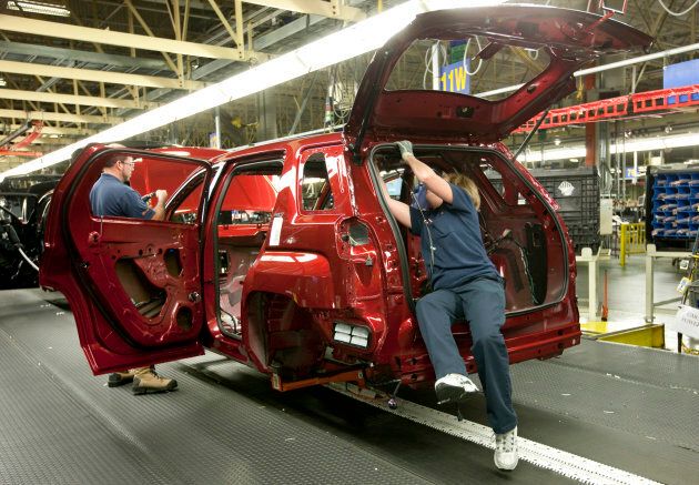 Workers install parts into a GMC Terrain vehicle at the CAMI Automotive Inc. plant assembly line in Ingersoll, Ont. Nov. 9, 2009.