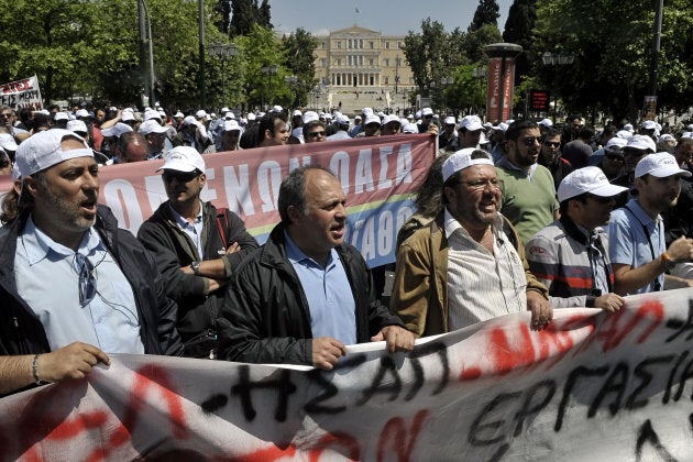 Public transport employees on strike shout slogans and walk behind a banner as they demonstrate outside the Greek Finance ministry in Athens on April 27, 2010, to protest against government's austerity measures.