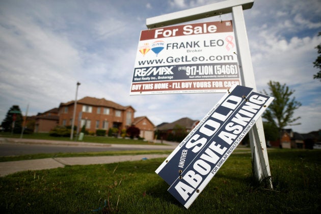 A real estate sign stands in front of housing in Vaughan, a suburb in Toronto, May 24, 2017.