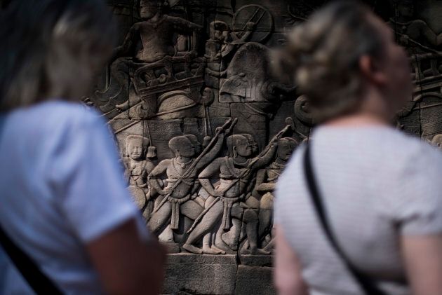 Tourists enjoy the figures carved on stone at Angkor Thom on Jan. 2, 2016 in Siem Riep, Cambodia. Angkor was the capital city of Khmer Empire, which flourished from approximately the 9th to 15th centuries. Angkor houses the magnificent Angkor Wat, one of Cambodia's popular tourist attractions.
