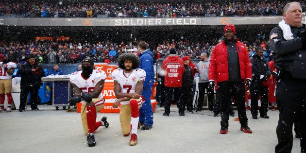 Eli Harold (58) and Colin Kaepernick (7) of the San Francisco 49ers kneel on the sideline, during the anthem, prior to the game against the Chicago Bears at Soldier Field on Dec. 4, 2016 in Chicago, Il.