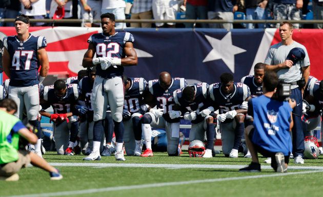Members of the New England Patriots take a knee during the national anthem before a game against the Houston Texans at Gillette Stadium.