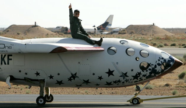 Pilot Mike Melville gives a thumbs up as he sits atop SpaceShipOne as it is towed following his historic flight of the world's first privately funded rocket plane beyond Earth's atmosphere at the Mojave Airport in California, U.S. on June 21, 2004.