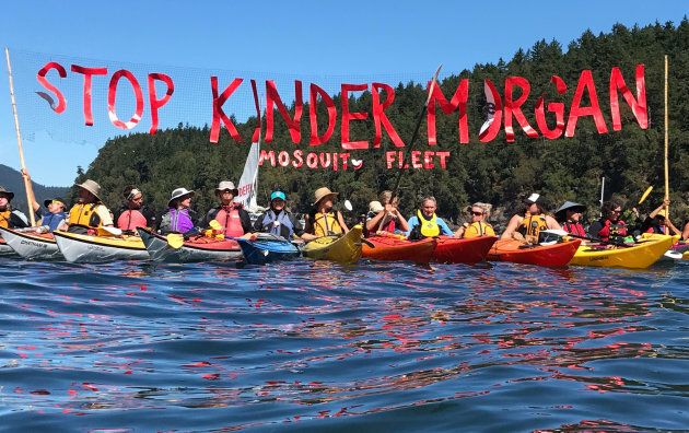 'Kayaktivists' hold up banner protesting plans by Kinder Morgan to build a pipeline during a water-based 'pipeline resistance training camp', held by Greenpeace and the Mosquito Fleet (a Pacific Northwest 'kayaktivist' group) in the San Juan Islands, in the waters just off the U.S.-Canada border on Aug. 26, 2017.