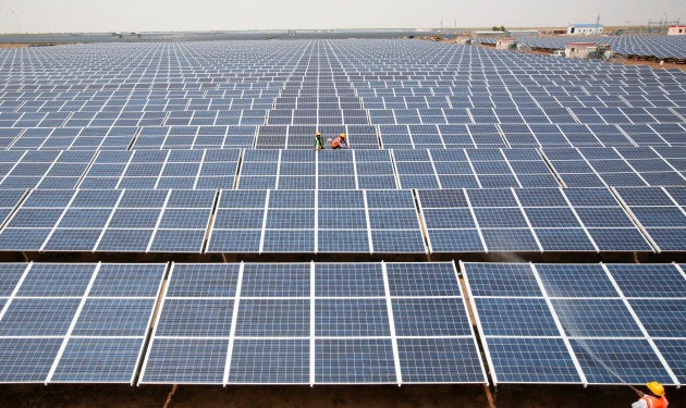 Workers install photovoltaic solar panels at the Gujarat solar park under construction in Charanka village in Patan district of the western Indian state of Gujarat April 14, 2012.