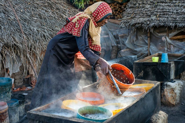 A woman prepares anchovies for drying at Mkokotoni village, Zanzibar, Tanzania.