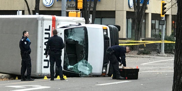 Edmonton police investigate the scene where a suspect hit pedestrians with a U-Haul truck, which then flipped at the intersection at 107 Street and 100 Avenue in front of the Matrix Hotel on Sunday.