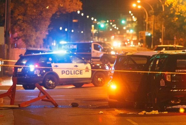 Police investigate the scene where a car crashed into a roadblock in Edmonton on Saturday.