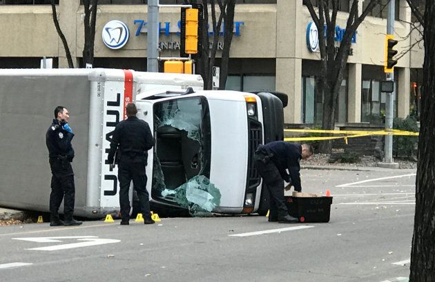 Edmonton Police investigate at the scene where a man hit pedestrians, then flipped the U-Haul truck he was driving, pictured at the intersection at 107 Street and 100th Avenue in front of the Matrix Hotel in Edmonton, Alta., on Oct. 1, 2017.