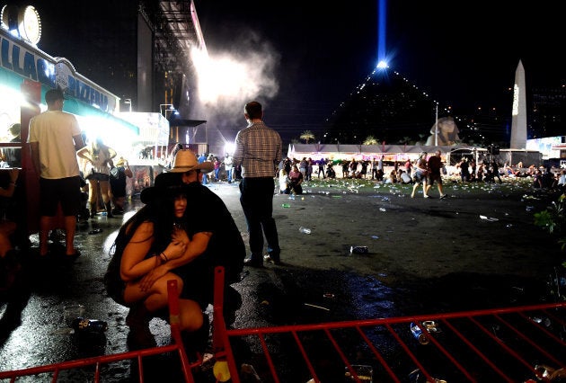 People take cover at the Route 91 Harvest country music festival after gun fire was heard on Sunday night in Las Vegas.