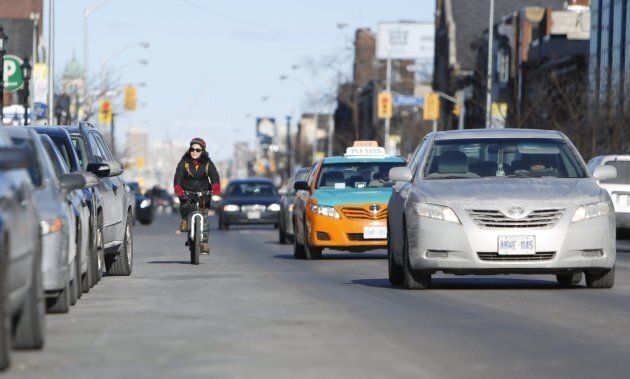 A cyclist going west with traffic on Danforth Avenue in Toronto on March 17, 2014.