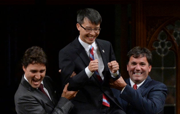 Justin Trudeau and MP Dominic LeBlanc are shown lifting Arnold Chan while escorting him in the House of Commons on Sept. 15, 2014.