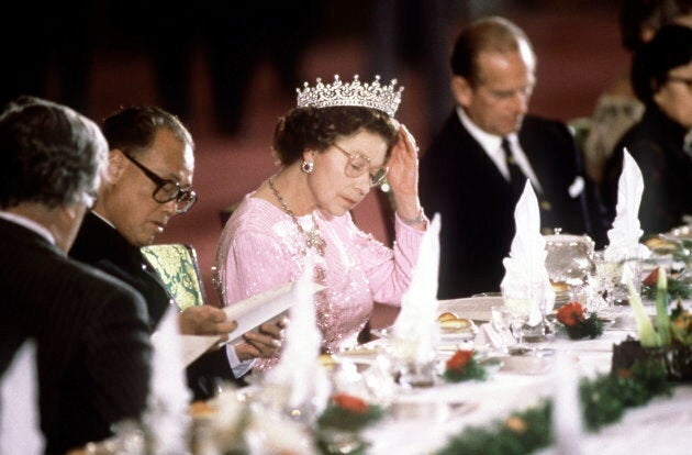 The Queen reading the menu before dinner is served at a banquet, (Photo by Tim Graham/Getty Images)