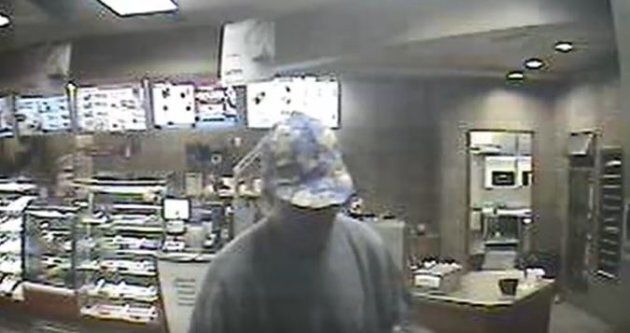 A screengrab from surveillance footage shows the suspect wearing what Windsor Police described as a "unique multicoloured purple and yellow baseball cap."
