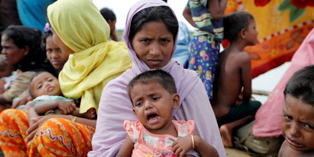 Rohingya refugees wait in a rice field after crossing the border in Palang Khali, Bangladesh, Oct. 9, 2017.