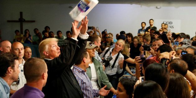 U.S. President Donald Trump tosses rolls of paper towels to people at a hurricane relief distribution center at Calvary Chapel in San Juan, Puerto Rico, October 3, 2017. REUTERS/Jonathan Ernst