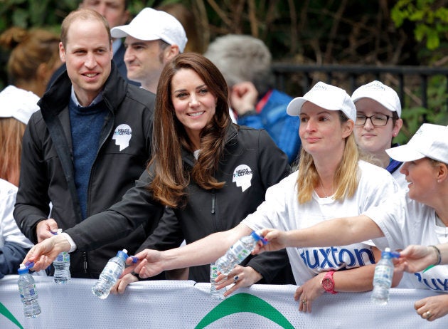 Prince William, Duke of Cambridge & Catherine, Duchess of Cambridge hand out water to runners taking part in the 2017 Virgin Money London Marathon on April 23, 2017 in London, England.