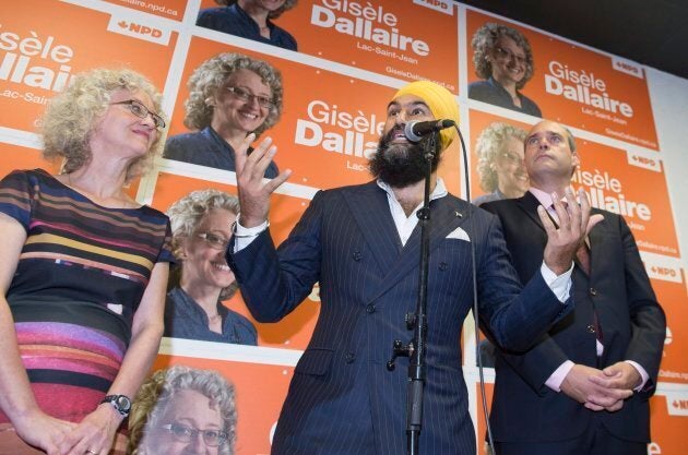 NDP Leader Jagmeet Singh responds to reporters questions during a campaign visit for local candidate Gisele Dallaire, left, as MP Guy Caron watches on Oct. 10, 2017 in Alma, Quebec.