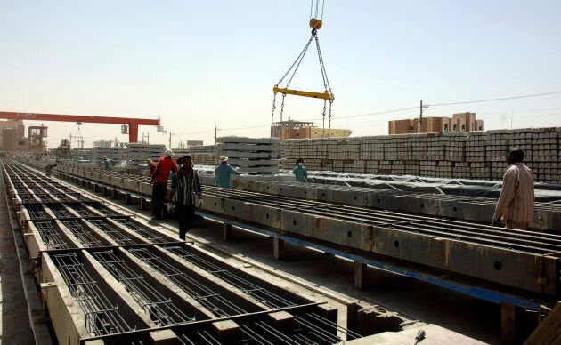 Chinese and Sudanese labourers work on the production of railway tracks at the Shanghai Huibo factory in Khartoum Feb. 23, 2012.