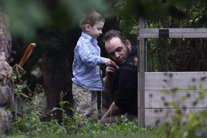 Joshua Boyle and one of his kids play in the garden at his parents' house in Smiths Falls, Ont., on Oct. 14, 2017.