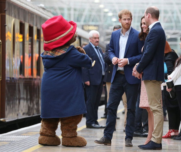 Britain's Catherine the Duchess of Cambridge, Prince William and Prince Harry stand next to a costumed figure of Paddington bear on platform 1 at Paddington Station, as they attend the Charities Forum in London, October 16, 2017.