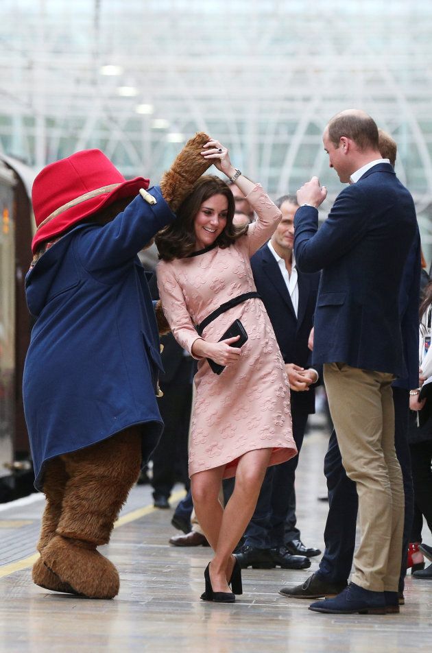 Britain's Prince William watches as his wife Catherine the Duchess of Cambridge dances with a costumed figure of Paddington bear on platform 1 at Paddington Station, as they attend the Charities Forum in London, October 16, 2017.