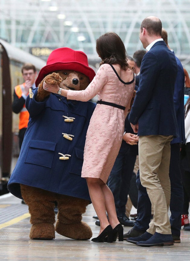 Britain's Prince William watches as his wife Catherine the Duchess of Cambridge dances with a costumed figure of Paddington bear on platform 1 at Paddington Station, as they attend the Charities Forum in London, October 16, 2017.