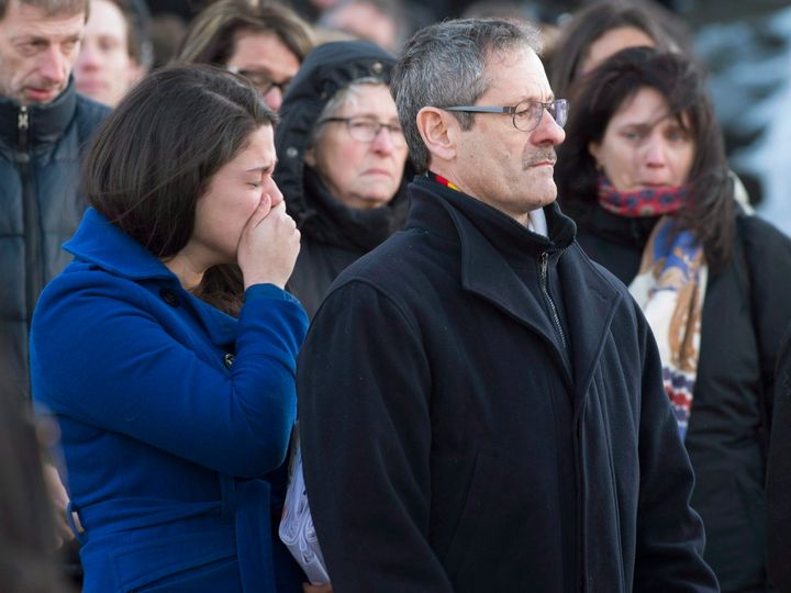 Joannie Vaillancourt, left, wife of Lac-Simon police officer Thierry LeRoux cries while his father Michel LeRoux stands at the end of the funeral service for police officer Thierry LeRoux Friday, February 26, 2016 in Saguenay, Que. LeRoux died tragically in a shooting in Lac-Simon, Que. on Feb. 13, 2016.