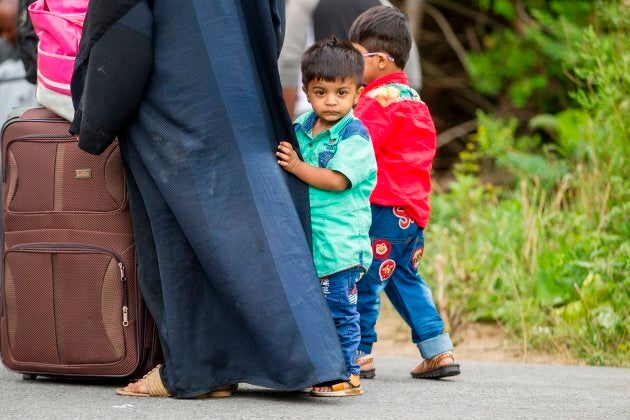 A long line of asylum seekers wait to illegally cross the Canada/U.S. border near Champlain, N.Y. on Aug. 6, 2017.