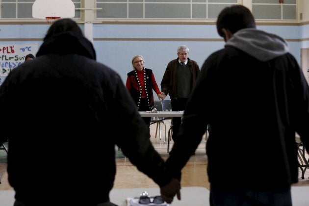 Canada's Indigenous Affairs Minister Carolyn Bennett, centre left, and New Democratic Party MP Charlie Angus, centre right, take part in a prayer at the start of a meeting with youth in the Attawapiskat First Nation in northern Ontario, April 18, 2016 after a suicide crisis state of emergency was declared.