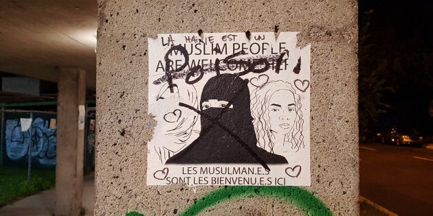 A defaced pro-refugee sign in Montreal.