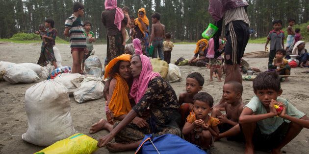 On Sept. 7, 2017, newly arrived Rohingya refugees sit at Shamlapur beach in Cox's Bazar district in Bangladesh, after travelling for five hours in a boat across the open waters of the Bay of Bengal.