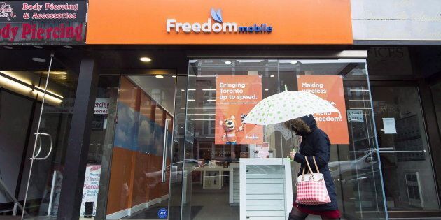 A woman walks past the rebranded signage of Freedom Mobile, in Toronto on Nov. 24, 2016. Freedom Mobile's new wireless plans include 10 GB of data for $50.