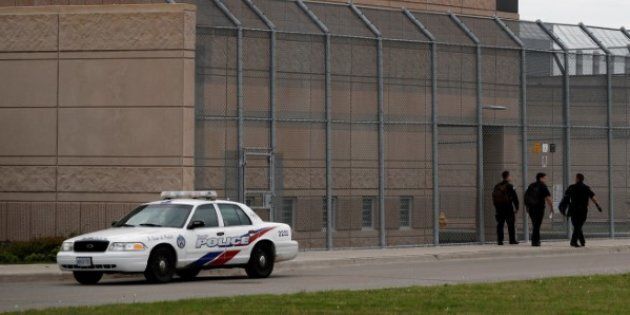 Officers walk by a police car in front of the Toronto South Detention Centre on May 24, 2017.