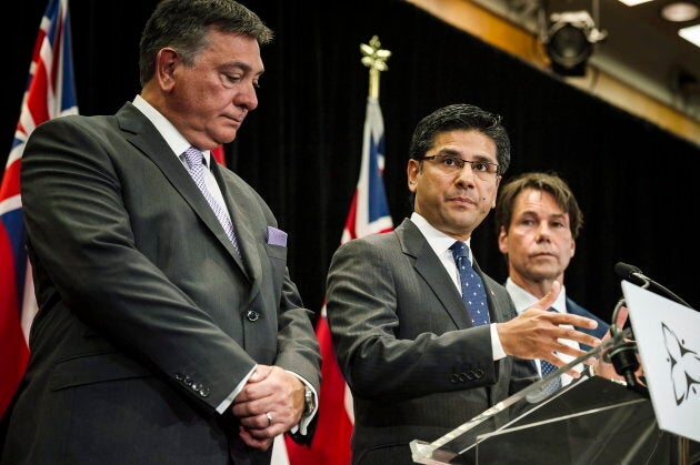 Attorney General Yasir Naqvi in between Minister of Finance Charles Sousa, left, and Minister of Health and Long-Term Care Eric Hoskins, right, in Toronto on Sept. 8, 2017.