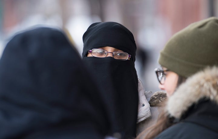 People rally outside the Khadijah Islamic Centre in the Montreal borough of Pointe-Saint-Charles, Friday, Feb. 3, 2017, in a show of support after vandals broke a window and pelted the building with eggs.