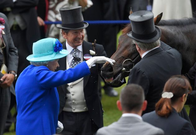 Queen Elizabeth pats her horse Dartmouth after winning the 3.40 Hardwicke Stakes race.