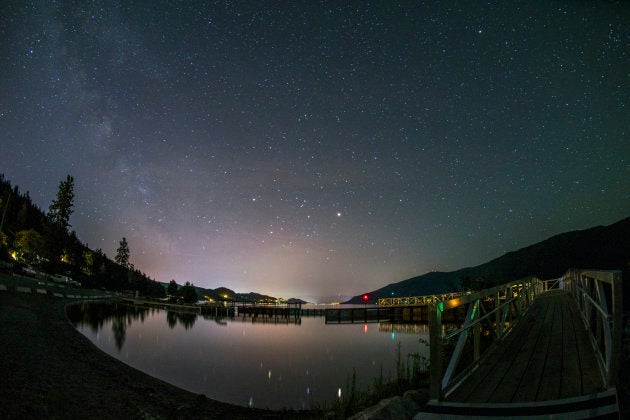 A calm Okanagan Lake at night beneath the stars of the Milky Way galaxy.