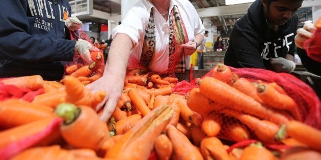 Gail Nyberg, former head of Daily Bread Food Bank, and student volunteers from Stephen Leacock Collegiate help sort carrots at the Daily Bread Food Bank.