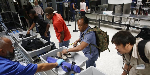 Travelers use automated screening lanes at Miami International Airport.