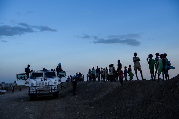 Children gather around a United Nations armoured personnel carrier as they watch tensions between different communities build up following the escalation of a dispute involving young men in the Protection of Civilians (PoC) site in Bentiu, South Sudan, Sunday, April 30, 2017.